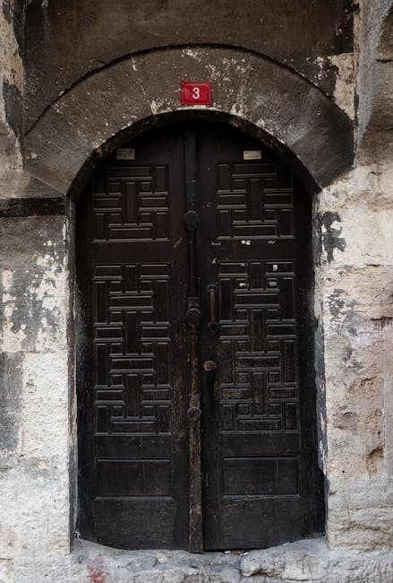 A heavy black wooden door with the number 3